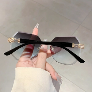 Detailed close-up of rimless gradient lenses with golden metal hollow-out hardware hinges