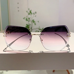 Detail of rimless irregular sunglasses with purple gradient lenses and gold temples