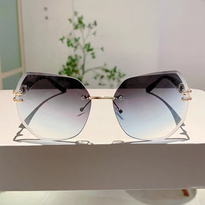 Close-up of rimless gradient lenses with precision geometric cutting and gold metal accents