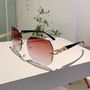 Detail of rimless gradient lenses and gold metal temples with intricate hollow carvings