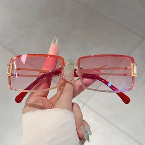 Detail of pink gradient sunglasses with red temples and rhinestone-studded gold hardware