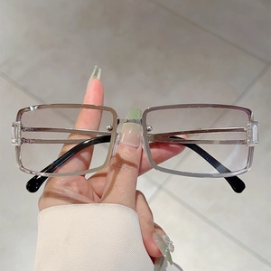 Close-up of silver square metal frame sunglasses with engraved temples and clear lens