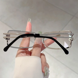 Detail of silver square metal frame sunglasses with hollow temple design and clear lenses