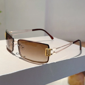 Detail of golden metal hinges and geometric accents on brown gradient sunglasses