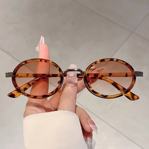 Détail de lunettes de soleil ovales vintage avec monture écaille et verres marron