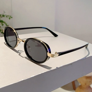 Détail de lunettes steampunk ovales avec charnières dorées sur un support en pierre