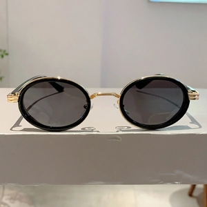Détail de lunettes de soleil ovales rétro avec monture dorée et décor de charnière