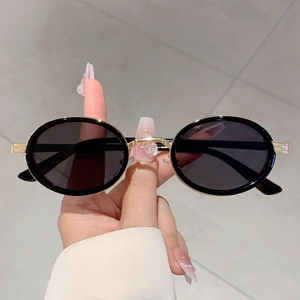 Lunettes de soleil rétro ovales steampunk avec monture noire et branches dorées