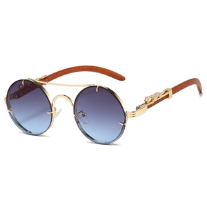 Detail of vintage sun glasses with gold panther emblem and wood grain texture arms