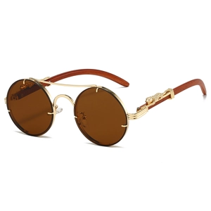 Detail of gold metal bridge and leopard head carving on vintage round sunglasses