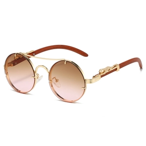 Detail of luxury sunglasses with gold panther relief, wooden temples and gradient lenses