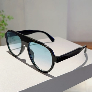 Detail view of large aviator sunglasses featuring black frames and blue gradient lenses