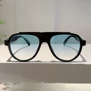 Detail of flat top aviator sunglasses with black frame and blue gradient lenses