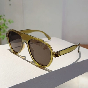 Side view of olive green aviator sunglasses with brown lenses on a white display
