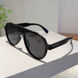 Detail showing oversized black pilot sunglasses on a modern geometric display stand