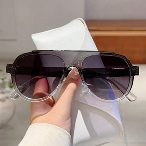 Oversized grey gradient aviator sunglasses with a white foldable leather storage case