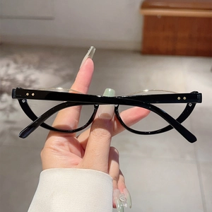 Dettaglio montatura cat-eye con cerniere a rivetti e raffinato ponte in metallo dorato