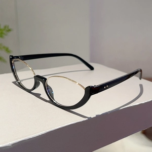 Dettaglio di occhiali cat-eye semi-rimless con montatura nera e dorata