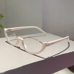 Dettaglio degli occhiali cat-eye bianco crema con elegante bordo superiore in metallo dorato
