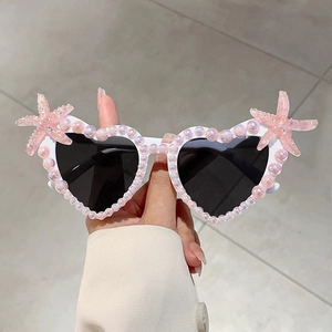 Detailansicht der herzförmigen Sonnenbrille mit rosa Perlen und Seestern für Partys