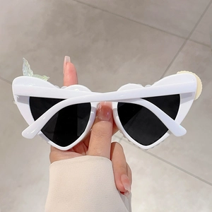 Details einer weißen Herz-Sonnenbrille mit Blumen- und Schmetterlingsflügel-Deko