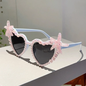 Detailansicht der herzförmigen Sonnenbrille mit rosa Perlen und Seestern-Dekor