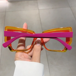 Macro detail showing translucent orange frame and purple matte temple of geometric glasses