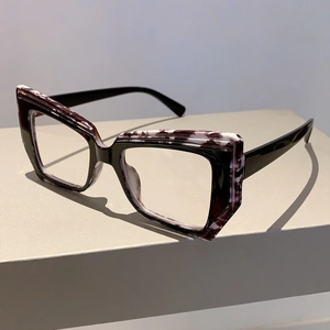 Detail of geometric cat-eye glasses frame with purple marble and black layered texture