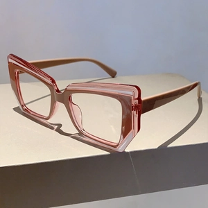 Detailed close-up of stylish pink cat-eye eyeglass frames with thick resin texture