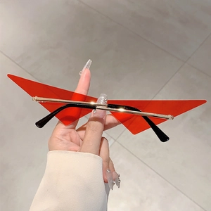 Vue macro de lunettes triangulaires rouges futuristes avec monture dorée à la main