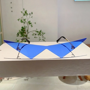 Gros plan de lunettes de soleil triangulaires bleues sans monture avec branches dorées