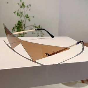 Détail de lunettes de soleil triangulaires avec verres bruns et branches dorées