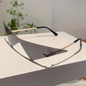 Détail macro de lunettes de soleil triangle sans monture avec verres gris foncé et branches or