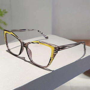 Detail of cat eye glasses frame with translucent grey patterns and yellow accents