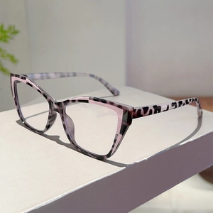 Detail view of pink and leopard print cat eye glasses on a minimalist display stand
