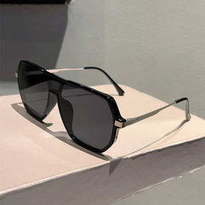 Side view of oversized pilot sunglasses with thick black frames and silver metal temples
