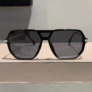 Detail of pilot sunglasses showing silver metal square accents on black frames