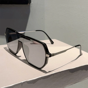 Macro detail of silver mirrored lenses and slim metallic hinges on oversized aviator sunglasses