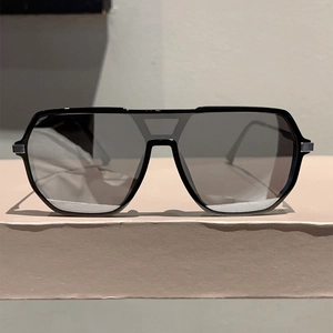 Close-up of oversized aviator sunglasses with black frame and integrated double bridge