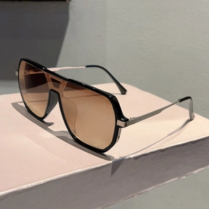 Macro detail of fashionable pilot sunglasses showing silver metal hinges and brown lenses