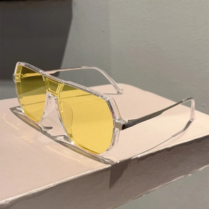 Detail of pilot sunglasses with yellow lenses, transparent frame and metal temples