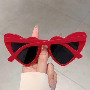 Detailansicht der roten herzförmigen Sonnenbrille mit dunklen Gläsern und PC-Rahmen