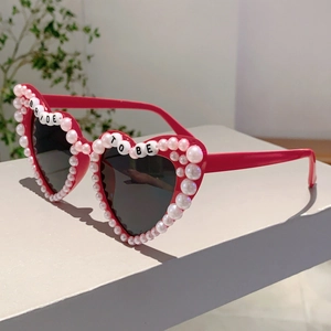 Detail von rosa Herz-Sonnenbrille mit weißen Perlen und BRIDE TO BE Buchstaben-Perlen