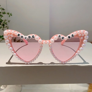 Detail der rosafarbenen Herz-Sonnenbrille mit weißen Perlen und Bride To Be Schriftzug