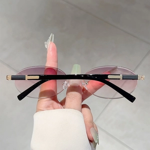 Detail of rimless oval sunglasses with pink-purple gradient lenses and gold-tone accents