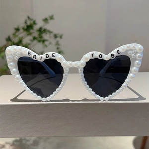 Detail von weißer Herz-Sonnenbrille mit Perlen und Bride To Be Schriftzug