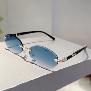 Detail of blue gradient frameless oval sunglasses with golden metal hinge and temples