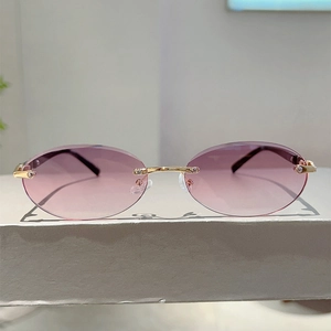 Detail view of purple gradient lenses and gold metal bridge on rimless oval sunglasses
