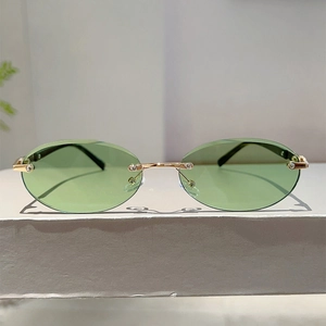 Detail of rimless oval sunglasses with gold metal bridge and sparkling rhinestone accents