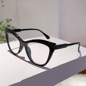 Detail of glossy black cat-eye glasses frame on a minimalist pedestal display